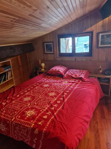 - une chambre avec un grand lit rouge et 2 oreillers dans l'établissement Maison de village, à La Brigue