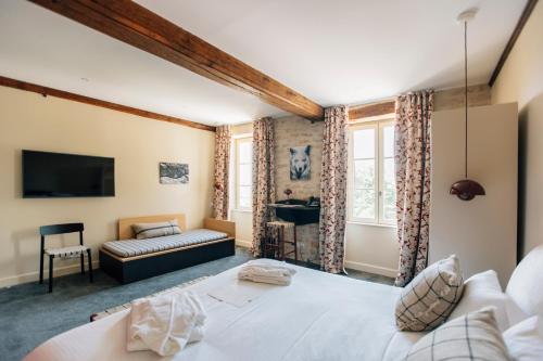 a bedroom with a large white bed and a couch at Castel de Très Girard - Hotel & Restaurant - Teritoria in Morey-Saint-Denis
