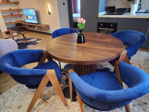 a table with blue chairs and a vase with flowers at Dream house 22 in Istanbul