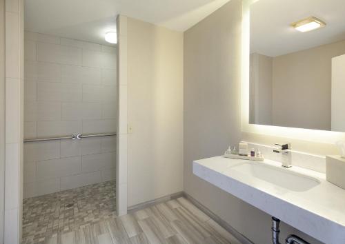 uma casa de banho com um lavatório e um espelho em Spyglass Inn em Pismo Beach