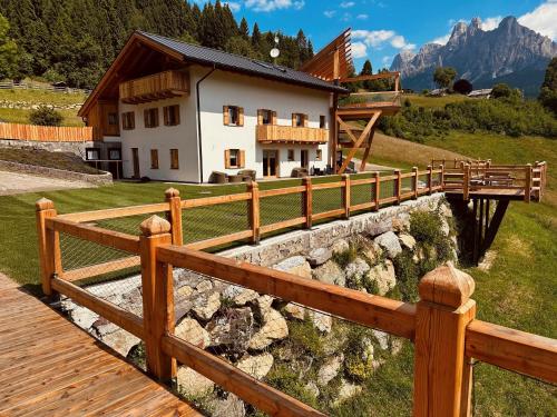 a wooden fence in front of a house at B&B Maso al Cervo in Fiera di Primiero