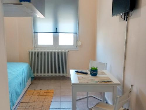 een kleine kamer met een tafel en een bed bij central apartments Eretria in Eretria