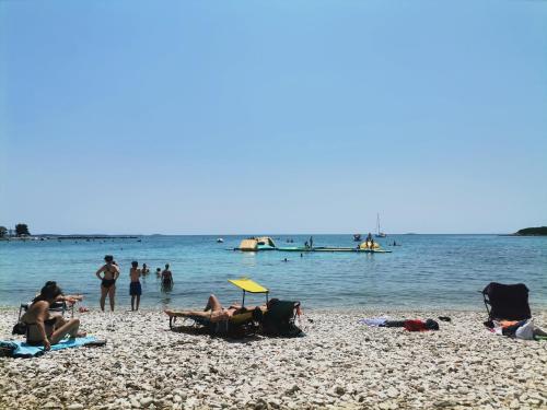 a group of people on a beach near the water at Studio Luna in Bale