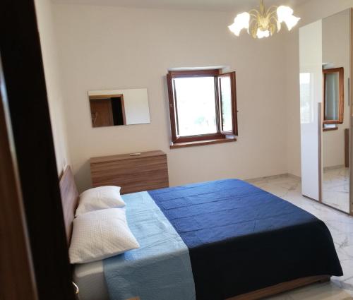 um quarto com uma cama azul e uma janela em Il papavero verde em Lucignano