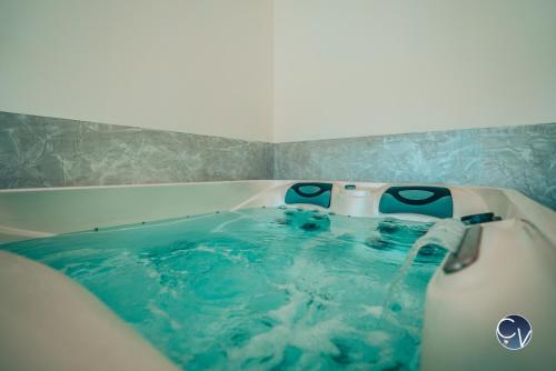 wanna z błękitną wodą w łazience w obiekcie Villa le Thor Piscine Billard Sauna et Jacuzzi w mieście Le Thor