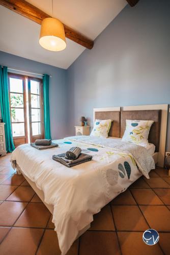 a bedroom with a large bed with towels on it at Villa le Thor Piscine Billard Sauna et Jacuzzi in Le Thor