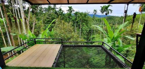 a balcony with a wooden platform in a forest at Chill chill homestay in Ban Khao Thalu