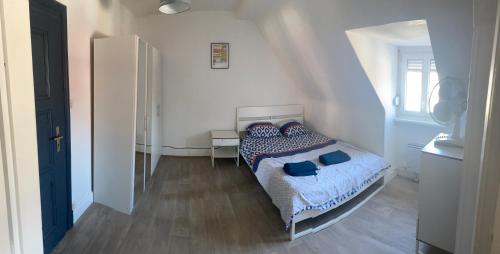 Un dormitorio con una cama con almohadas azules. en Mury 3 en Estrasburgo