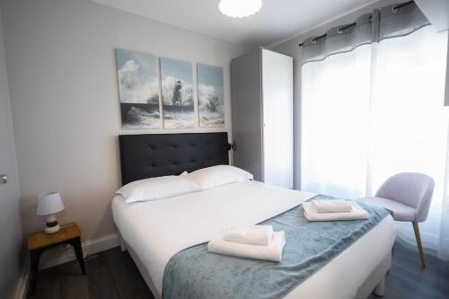 - une chambre avec un lit et 2 serviettes dans l'établissement Le Cabestan, appartement proche plage Morgat, à Crozon