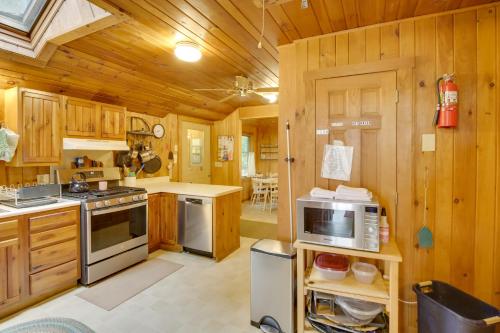a kitchen with wooden cabinets and a stove top oven at Waterfront Raymond Vacation Rental with Boat Dock! in Raymond