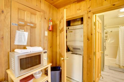 eine Küche mit einer Mikrowelle und ein TV in einer Hütte in der Unterkunft Waterfront Raymond Vacation Rental with Boat Dock! in Raymond