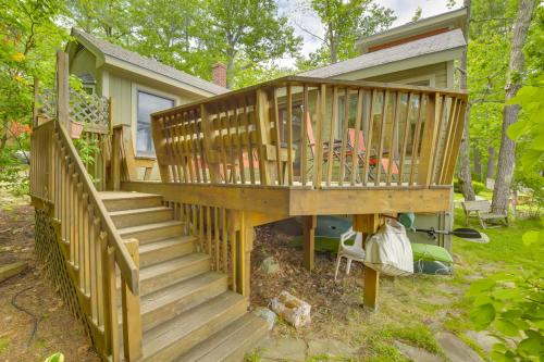 a large wooden deck with two chairs on it at Waterfront Raymond Vacation Rental with Boat Dock! in Raymond