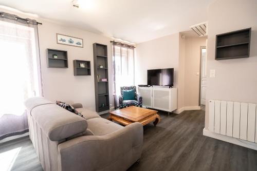 un salon avec un canapé et une table dans l'établissement Le Cabestan, appartement proche plage Morgat, à Crozon