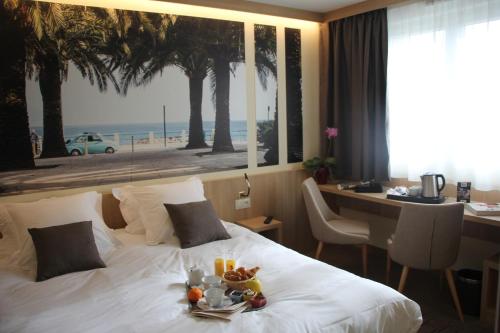 Un pat sau paturi într-o cameră la Brit Hotel Montargis