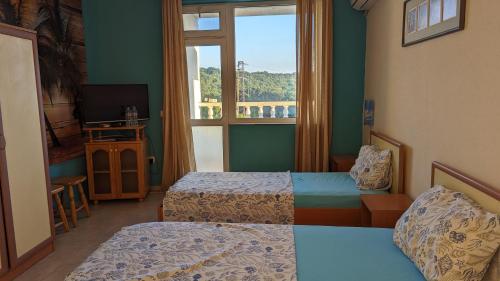 a hotel room with two beds and a window at Guest House Chalakov in Sinemorets