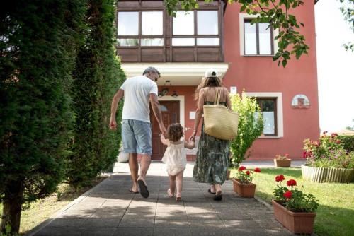 a man and a woman walking down a sidewalk with a child at Posada de Suesa in Suesa
