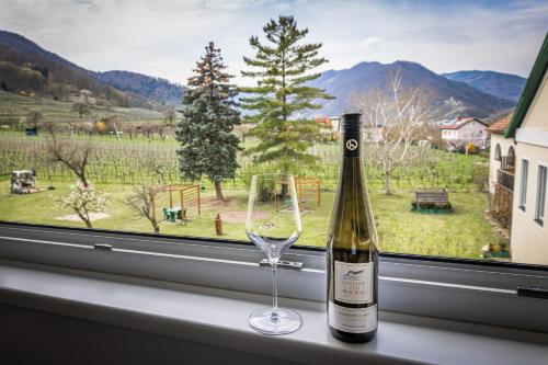 a bottle of wine and a glass on a window sill at Gasthof zur Wachau in Hofarnsdorf