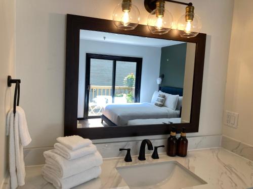 a bathroom with a sink and a mirror with a bed at Hotel Frisco in Frisco