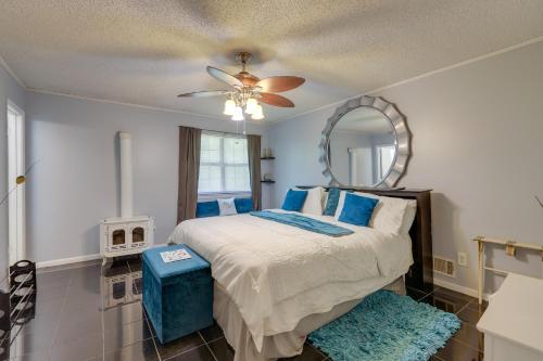 1 dormitorio con 1 cama con ventilador de techo y espejo en Jonesboro Home with Screened-In Porch and Fire Pit!, en Jonesboro