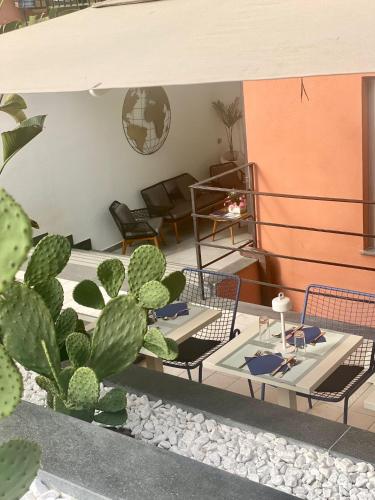 a living room with tables and chairs and a cactus at Hotel Portum in Giardini Naxos