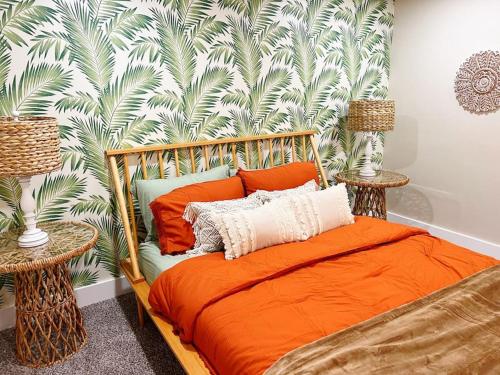 um quarto com uma cama laranja e um papel de parede tropical em NEW: Tulum Oasis in Denver w/ Hot Tub & Games em Denver