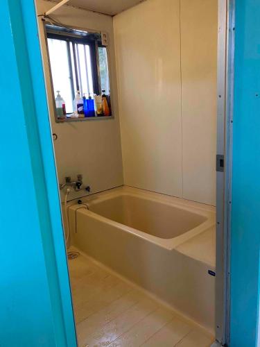 a bath tub in a bathroom with a window at "Cherry House" is Direct to Narita,Haneda AP, Disney, Asakusa, Skytree Tower, Tokyo in Matsudo