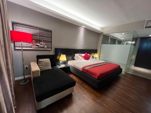 a bedroom with a bed and a chair and a lamp at The Shore Melaka in Melaka