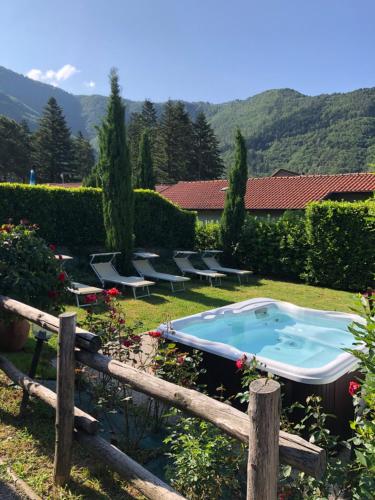 ein Pool in einem Garten mit einem Zaun in der Unterkunft Albergo Miramonti in Comano