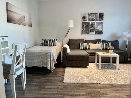 a living room with a couch and a table at Kotikaksio Serene in Lahti