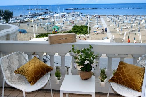 a balcony with chairs and a view of a beach at Villa La Torretta Luxury B&B - Adults Only - in Rimini