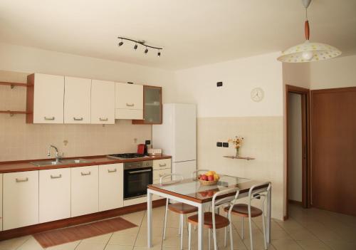 een keuken met witte kasten en een tafel met stoelen bij Sole&Luna Apartment in Trento