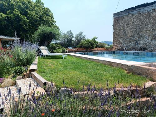 a swimming pool in a garden with a bench at Mas de l'Amme in Valréas