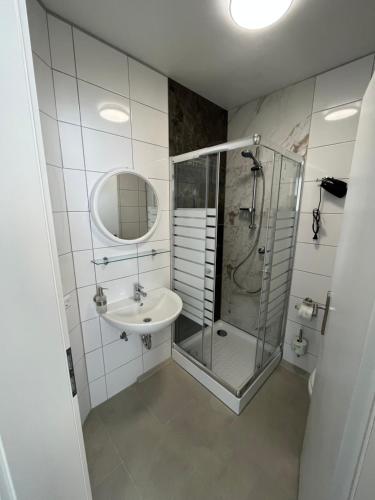a bathroom with a glass shower and a sink at Übernachtung by Tag in Kassel