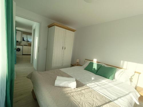 1 dormitorio con 1 cama grande con sábanas verdes y blancas en Tiny Village Mamaia Nord - House 4, en Mamaia Nord – Năvodari