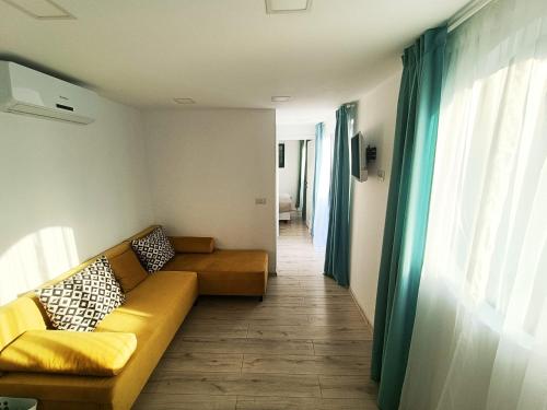 Tiny Village Mamaia Nord - House 4 في مامايا نورد نافورداي: غرفة معيشة مع أريكة وممر