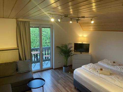 een kamer met 2 bedden, een bank en een televisie bij Bavaria Home: Balkon, Küche, Netflix in Wolnzach