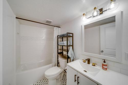 La salle de bains blanche est pourvue d'un lavabo, de toilettes et d'un miroir. dans l'établissement Pet-Friendly Idaho Retreat Near Beaches and Hiking!, à Coeur d'Alene