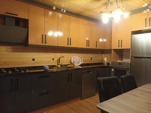 uma cozinha com armários de madeira e uma mesa de cozinha em Gürgen House em Cayeli