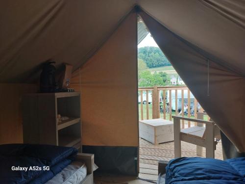 Zelt mit Blick auf einen Balkon und einem Bett in der Unterkunft Minitent Reisdorf in Reisdorf