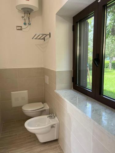 uma casa de banho com um WC, um lavatório e uma janela em Residenza Giulia em Scanzano Jonico