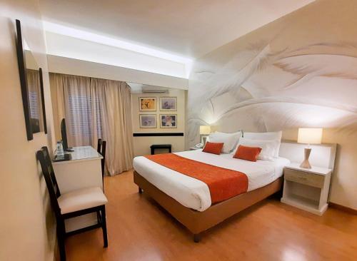 ファティマにあるHotel Aleluiaの大きなベッドと椅子が備わるホテルルームです。