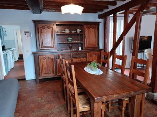 a dining room with a wooden table and chairs at La Maison Normandelys in Les Andelys