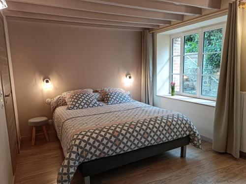 a bedroom with a bed and a window at La Maison Normandelys in Les Andelys