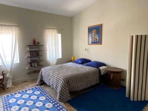 1 dormitorio con cama y alfombra azul en La Paloma La Palme, en Lapalme