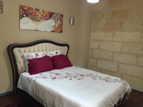 une chambre avec un lit blanc avec des oreillers rouges dans l'établissement Appartements Bordeaux Saint Michel, à Bordeaux