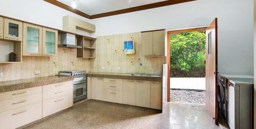 a kitchen with white cabinets and a sliding glass door at YAAN Udaipur in Udaipur