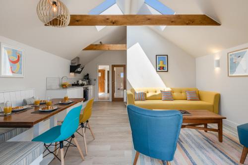 a living room with a yellow couch and blue chairs at Waterside Apartment in Paignton