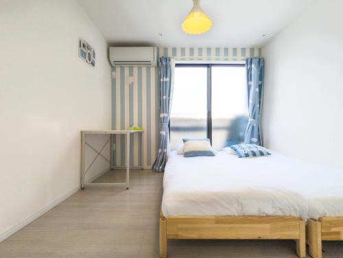 1 dormitorio con 2 camas y ventana en japan house itabashi, en Tokio