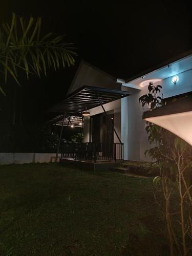 a house with a black awning at night at Teaside Inns in Vythiri