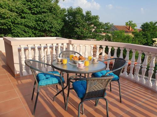 a table with chairs and a bowl of food on a balcony at Apartment Neli in Polača